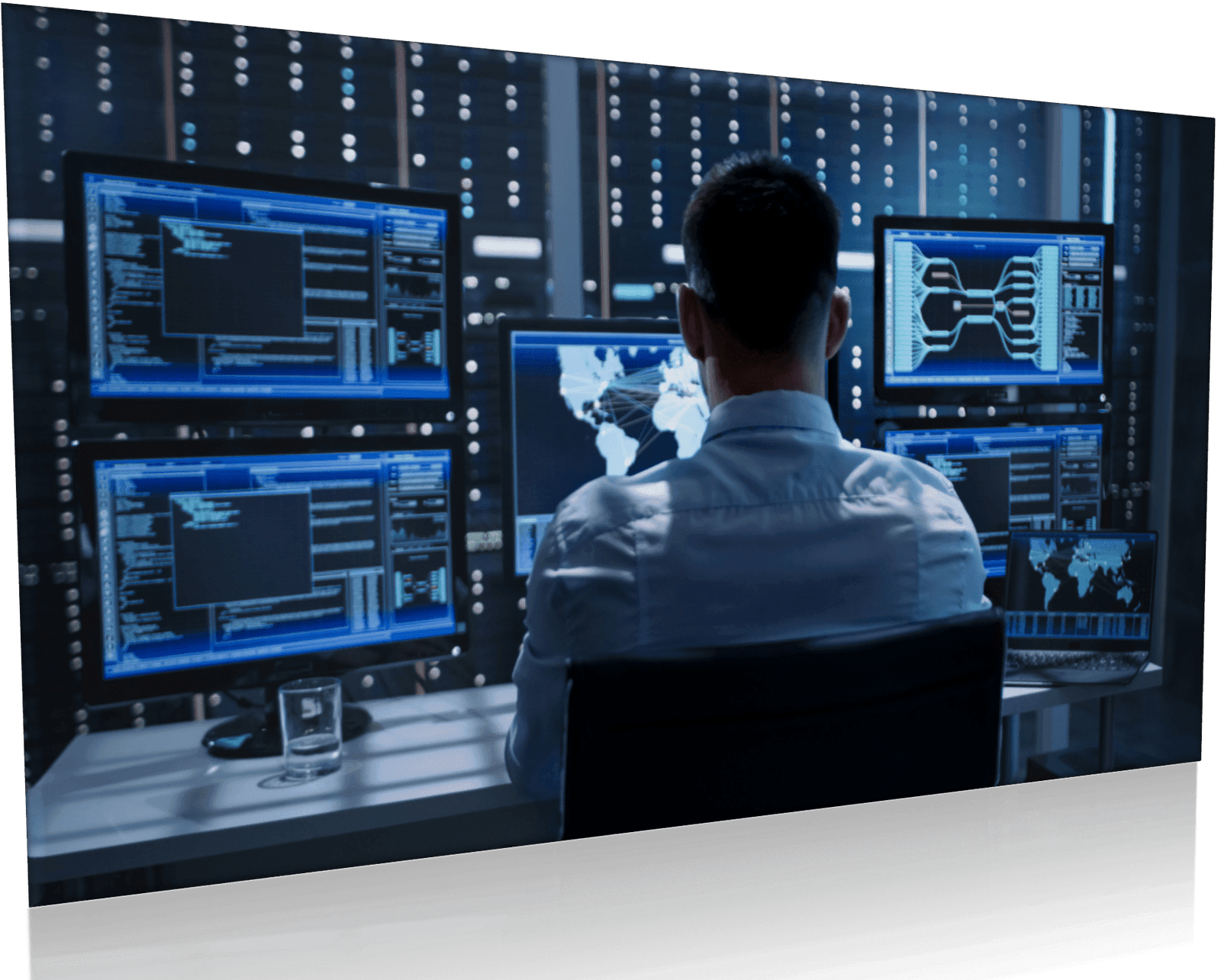 A man specialized in security sitting at a desk with several monitors in front of him.