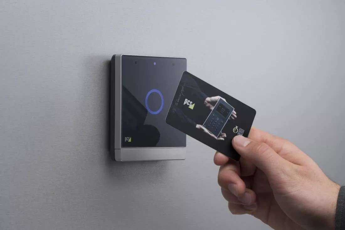 alt=1. A person holds a credit card beside a smart door lock, illustrating modern security and payment technology integration.