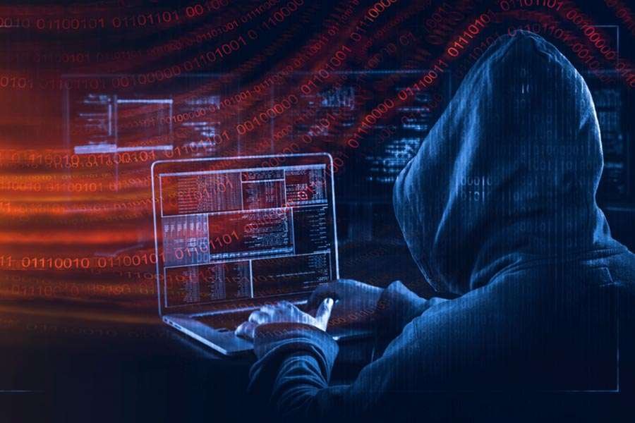 alt= A hoodie-clad person using a laptop, highlighting a scene of modern technology and personal engagement.
