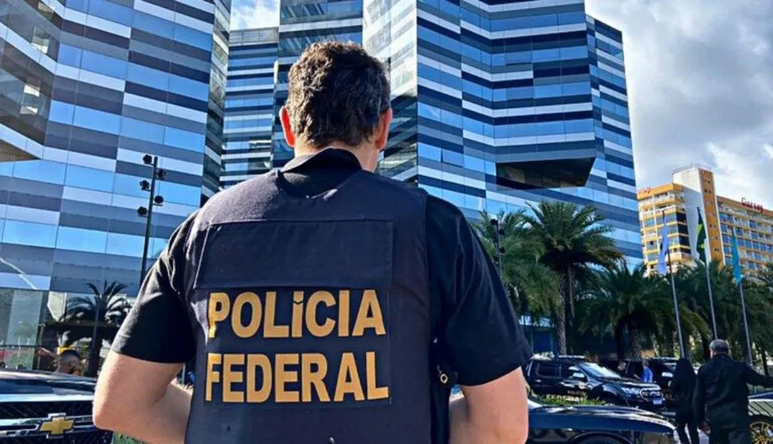 alt=A man wearing a police vest stands confidently in front of a building, ready for duty.