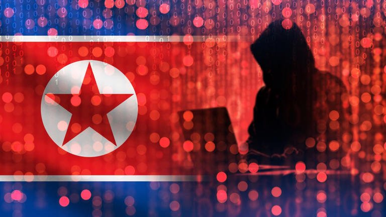 alt=Silhouette of a figure at a laptop against the North Korean flag, symbolizing cyber activities and hacking threats.