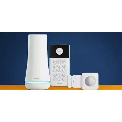alt=A home security system featuring a white base station, keypad, and motion sensor, set against a blue background with an orange surface.