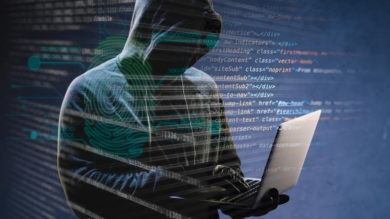 alt=Person in a hoodie typing on a laptop, overlaid with transparent lines of computer code and digital fingerprint graphics.